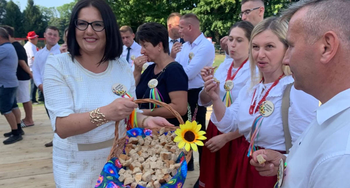 Wicestarosta powiatu Ewelina Kuś częstuje zgromadzonych dożynkowym chlebem.