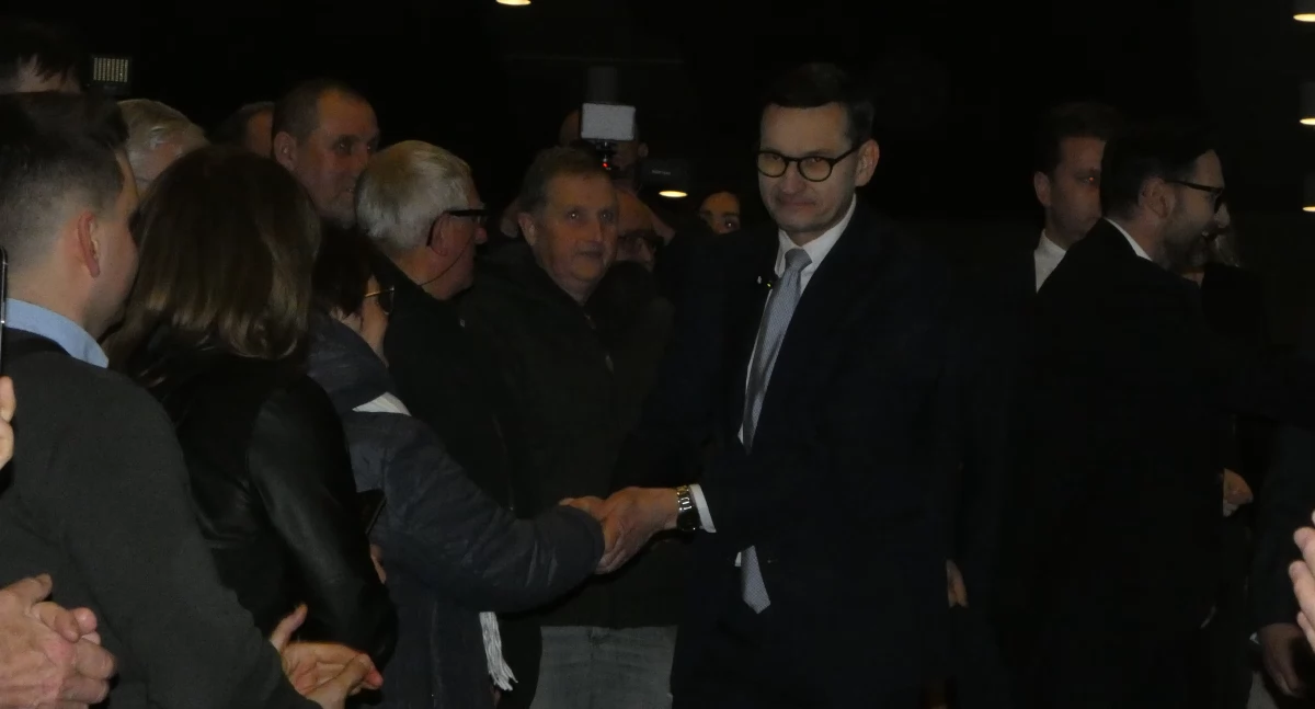 Mateusz Morawiecki i Daniel Obajtek witają się z zebranymi w sali widowiskowej DK Mors.
